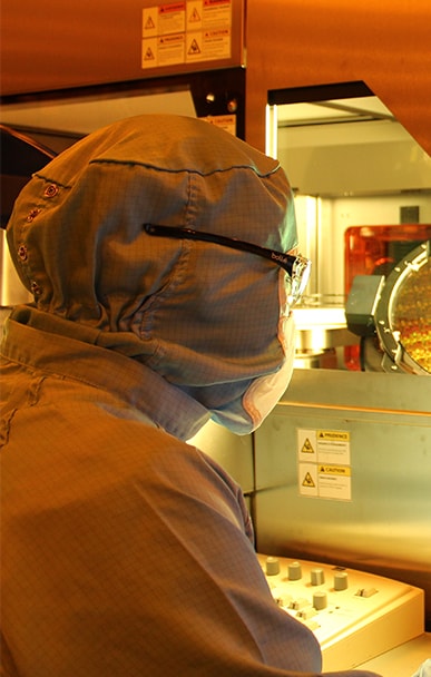 Engineer working in a cleanroom environment wearing protective suit