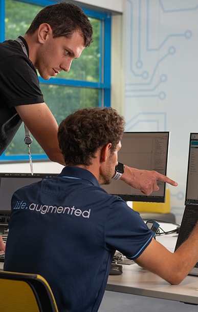 Engineers collaborating on a computer project in an office