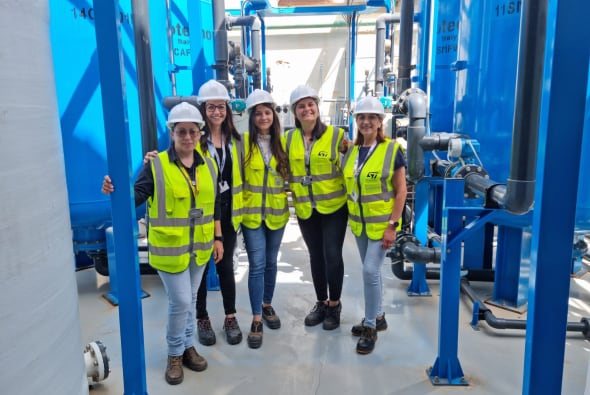 身穿安全服的女士站在水管前