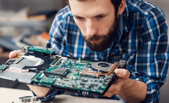 man inspecting electronic board