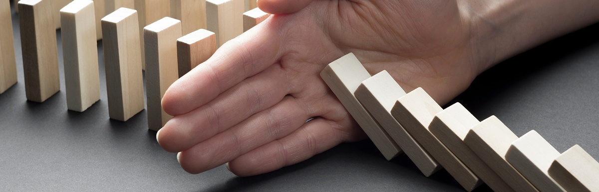 手扶将倒的多米诺骨牌