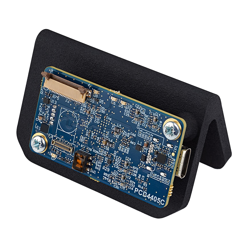 一块安装在黑色支架上的蓝色意法半导体PCB，上面嵌有各种电子元件和连接器，包括位于顶部的带状电缆连接器。