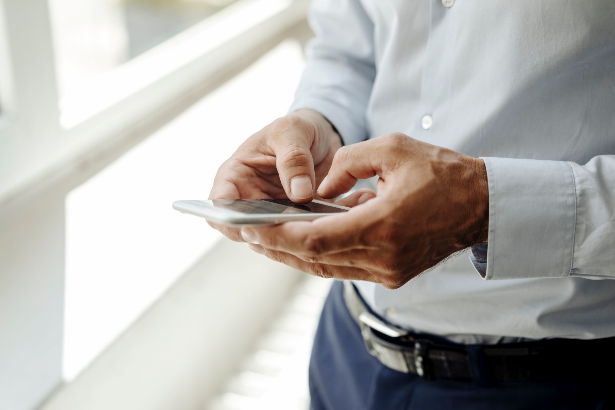 图片显示一条自动化制造装配线，配备安装在金属框架上的机械臂和传感器，沿传送带排列，重点展现高科技工业环境中的高精度机械设备。