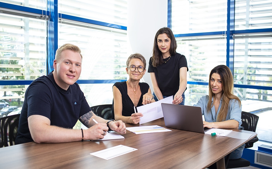 Group of employees sitting at a desk in an office